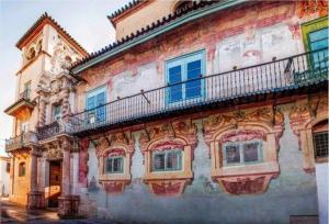 an old building with a balcony on the side of it at APARTAMENTOS TRES SOLES in Écija +3 photos