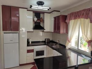 a kitchen with white appliances and a window at La casa de la Plaza - WIFI - Barbacoa - Chimenea in Cirueña