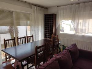 uma sala de jantar com uma mesa e cadeiras e um sofá em La casa de la Plaza - WIFI - Barbacoa - Chimenea em Cirueña