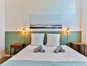 a bedroom with a white bed with two pillows at Maison de surfeurs, idéalement située in Les Sables-dʼOlonne
