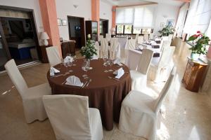 a dining room with a table and white chairs at Hotel Carmen in Krnica