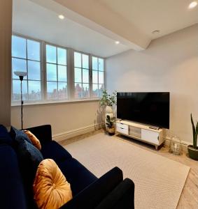 a living room with a blue couch and a flat screen tv at The Apartments Lytham Square in Lytham St Annes