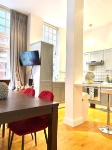 cocina con mesa y 2 sillas rojas en Sight Flats - SF02 - One Bedroom, en Londres