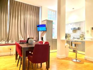 a kitchen and dining room with a table and red chairs at Sight Flats - SF02 - One Bedroom in London