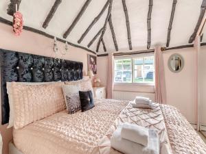 um quarto com uma cama grande e uma janela em Brittons Hill Cottage em Wavehorne