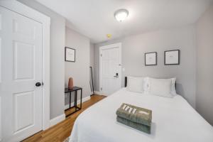 um quarto com uma cama branca e uma porta branca em 4BR1BTH South Boston Apt perfect for commutes em Boston
