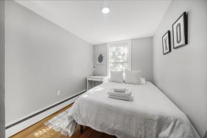 um quarto branco com uma cama com lençóis brancos em 4BR1BTH South Boston Apt perfect for commutes em Boston