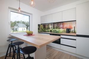 Una cocina con gabinetes blancos y una encimera de madera. en Hamak Lubiatowo, en Lubiatowo