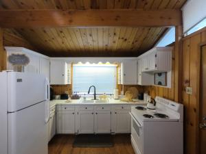 a kitchen with white appliances and a wooden ceiling at Bryce’s Zion House by Bryce Canyon National Park! in Panguitch