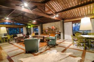 a living room with chairs and a couch and tables at Oasis Hotel Spa in Gravatá