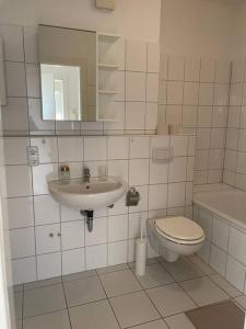 La salle de bains est pourvue d'un lavabo, de toilettes et d'un miroir. dans l'établissement Ruhig und zentral wohnen! MA3R, à Essen