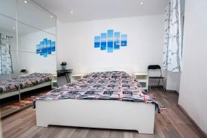 een witte slaapkamer met 2 bedden en een spiegel bij Apartman Puzzle in Rovinj