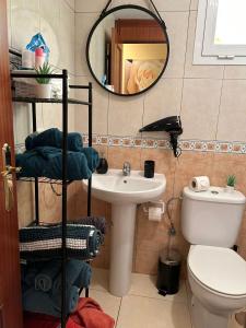 a bathroom with a sink and a toilet and a mirror at Casa Gloria in Los Abrigos