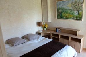 a bedroom with a bed and a desk and a painting at Gite Le Verger in Commes