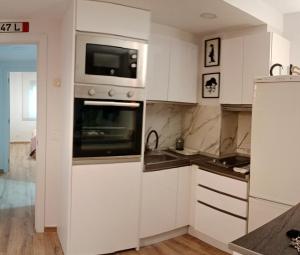 薩拉戈薩的住宿－Suite Lay，厨房配有白色橱柜和微波炉