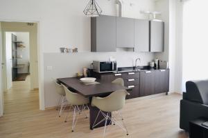 a kitchen with a table and chairs in a room at RivApartmentsDowntowN Travel in Riva del Garda