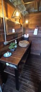 y baño con mesa de madera y lavamanos. en Glamping Montecarlo Lodge Cubo de Madera-Guatapé, 