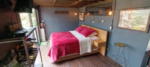 a bedroom with a bed in a tiny house at Glamping Montecarlo Lodge Cubo de Madera-Guatapé 