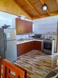 eine Küche mit einem weißen Kühlschrank und Holzschränken in der Unterkunft Casa de campo Santa Cruz in Palmilla