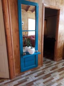 a blue cabinet with a mirror and a plant in it at Casa de campo Santa Cruz in Palmilla