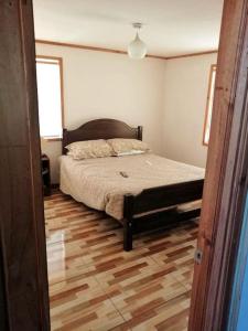 1 dormitorio con 1 cama y suelo de madera en Casa de campo Santa Cruz, en Palmilla