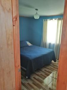 una camera blu con un letto e una finestra di Casa de campo Santa Cruz a Palmilla