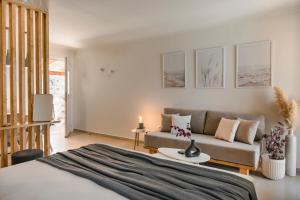 een slaapkamer met een bed en een bank bij Klio Seafront House, Sami Kefalonia in Sami