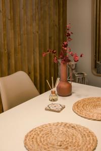 a white table with a vase with flowers in it at Cavaliere Seafront House - Klio in Sami +25 photos