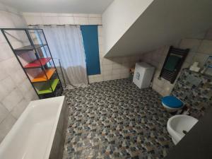 a bathroom with a tub and a toilet and a sink at Galeria Kolorów pokój rodzinny in Łódź