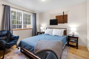 1 dormitorio con 1 cama azul y 1 silla en Indio Cabin en Bend