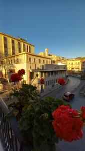 un balcone con fiori rossi su una strada della città di Cantunera SicilianRoom a Piazza Armerina