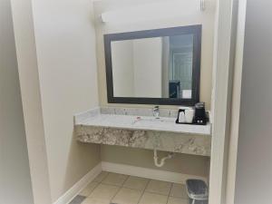 a bathroom with a sink and a mirror at Super 8 by Wyndham Picayune in Picayune