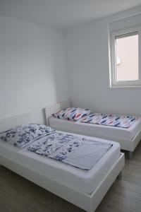 Duas camas num quarto com uma janela em Apartmani Villa Ana, Sibenik - Brodarica em Brodarica