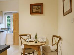 comedor con mesa, botella y sillas en Duffs Lodge - Beaufort Estate, en Belladrum