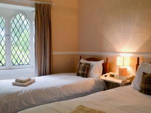 two beds in a room with a window at Duffs Lodge - Beaufort Estate in Belladrum
