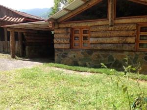 a log cabin with a grass yard in front of it at Hotel y Cabaña La Peña in Xilitla