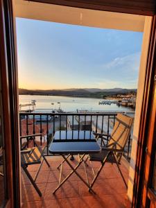 a balcony with two chairs and a view of a body of water at La Casa de la Bahía in San Vicente de la Barquera