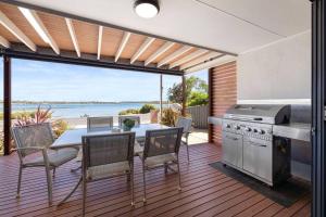 a kitchen and dining area with a view of the ocean at Almonta Apartments on the water front in Coffin Bay