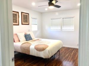 a bedroom with a bed with a ceiling fan at Mākaha House in Waianae