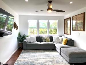 uma sala de estar com um sofá e uma ventoinha de tecto em Mākaha House em Waianae