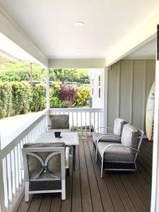 a screened porch with a table and chairs on a deck at Mākaha House in Waianae