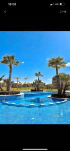 a picture of a swimming pool with palm trees at Marrakech golf City prestigia in Marrakesh