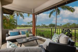 a screened in porch with a couch and a table at Mauna Lani KaMilo 217 in Waikoloa