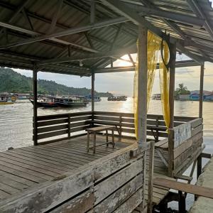 a dock with a table and a bench on the water at Jeminlin homestay, budget price in Kota Kinabalu