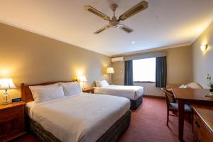 a hotel room with two beds and a desk at Gateway on Monash in Clayton North