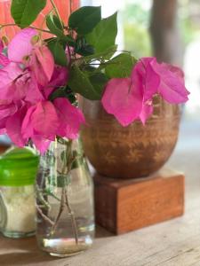 three vases with flowers in them on a table at Playa Casa Nohelia in Santo Domingo
