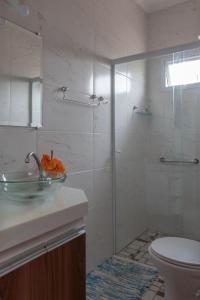a bathroom with a sink and a glass shower at Suites Mar e Lua em casa compartilhada in Ubatuba