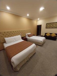 Habitación de hotel con 2 camas y sofá en Hotel Carvallo, en Cuenca