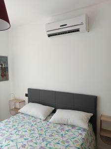 a bedroom with a bed with a air conditioner on the wall at Appartamento per 4, Metro B Monti Tiburtini, AC, Wi-Fi in Rome