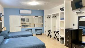 1 Schlafzimmer mit 2 Betten, einem TV und Regalen in der Unterkunft Departamento Loft Ejecutivo Privado Confortable Minisplit Amenidades in Torreón